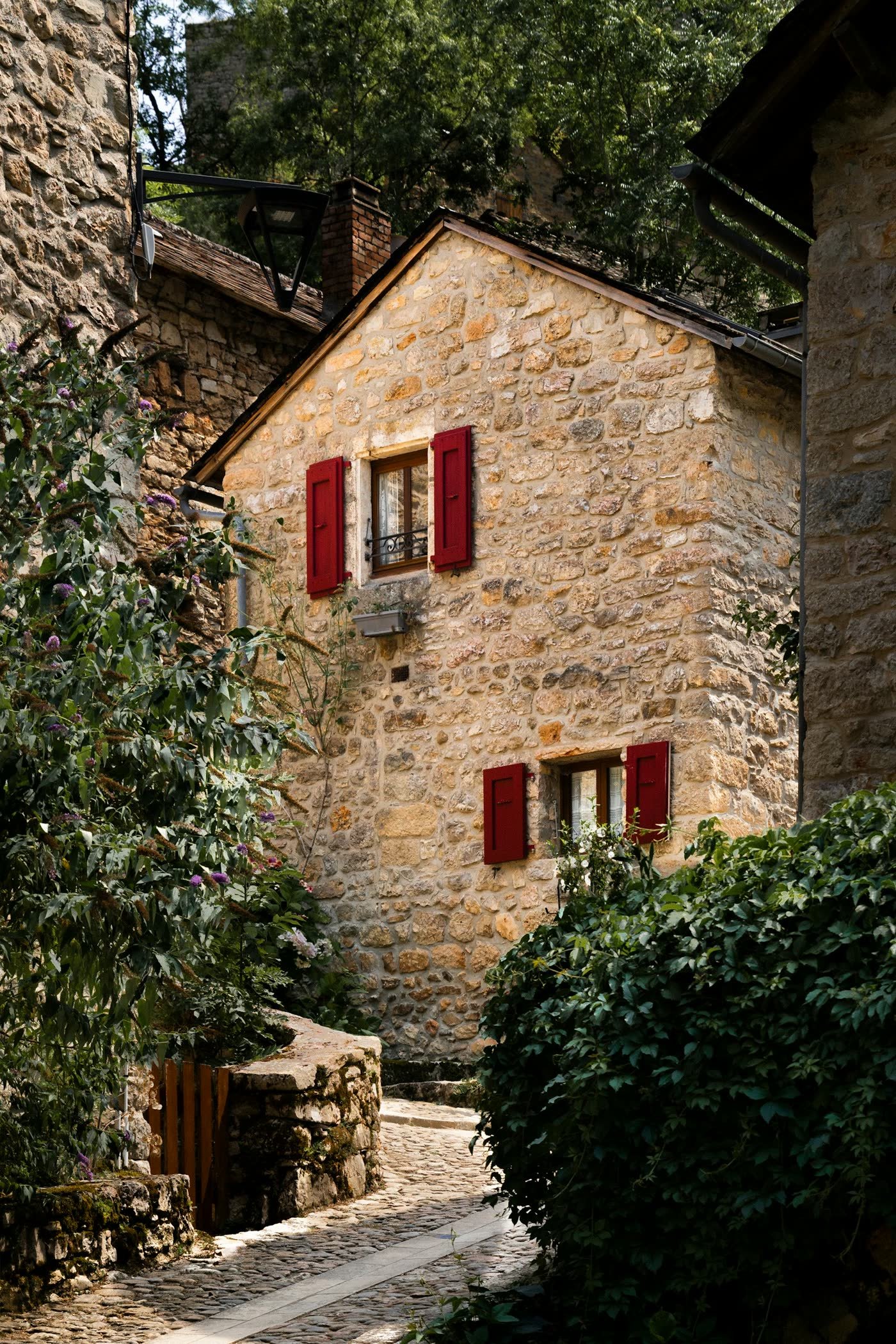 Façade en pierre aux volets rouges